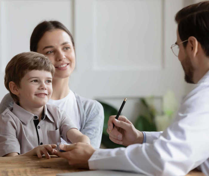 Mutter mit ihrem Sohn in einem Arztgespräch