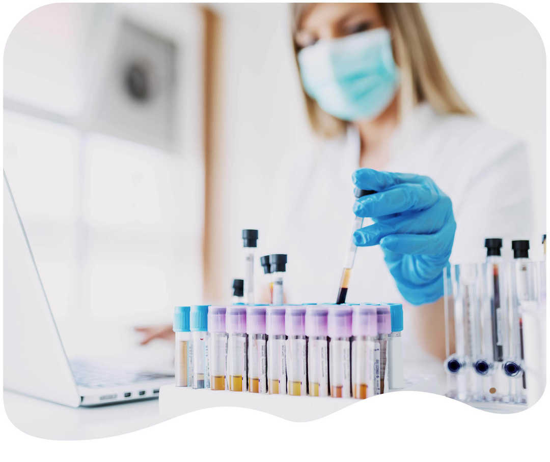 Labormitarbeiterin nimmt Probenröhrchen aus der Halterung