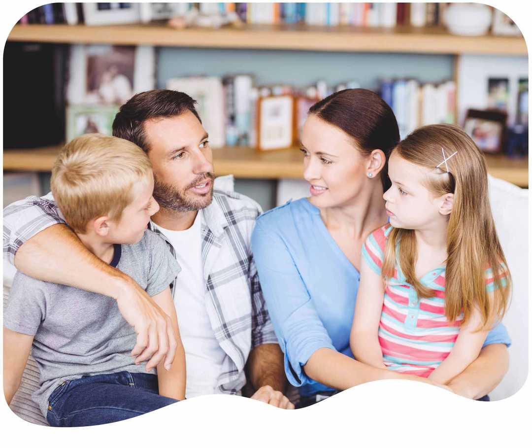 Vierköpfige Familie unterhält sich auf dem Sofa