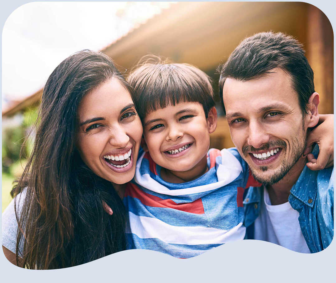 Paar mit Kind lacht herzlich in die Kamera