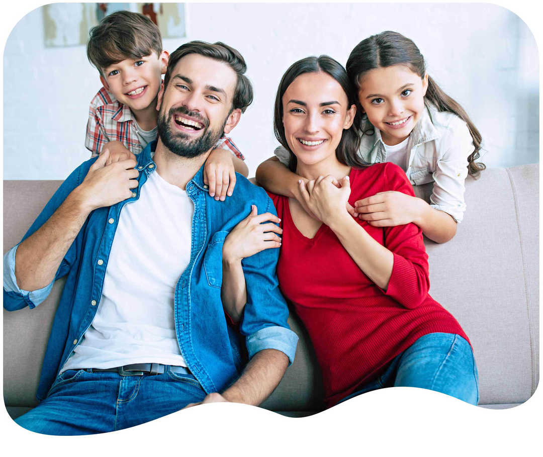 Eine vierköpfige Familie lacht in die Kamera