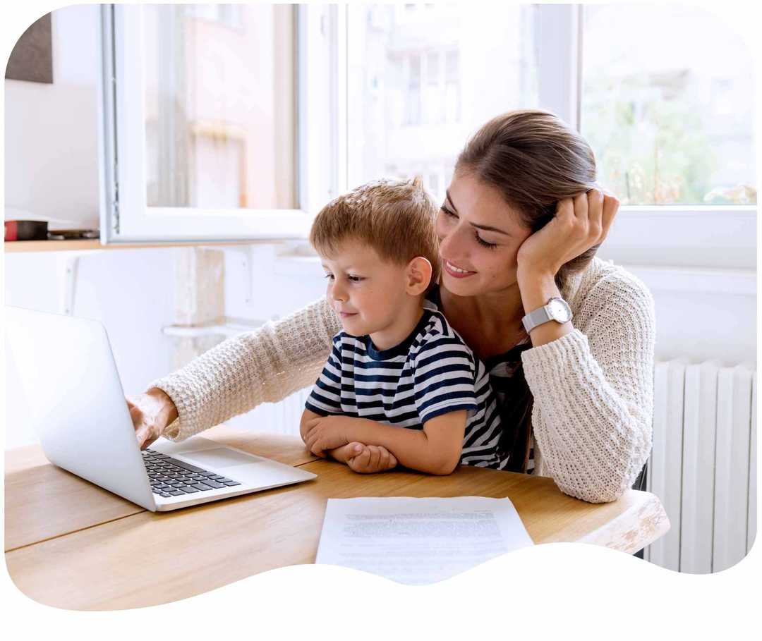 Mutter sitzt mit ihrem Sohn vor einem Laptop