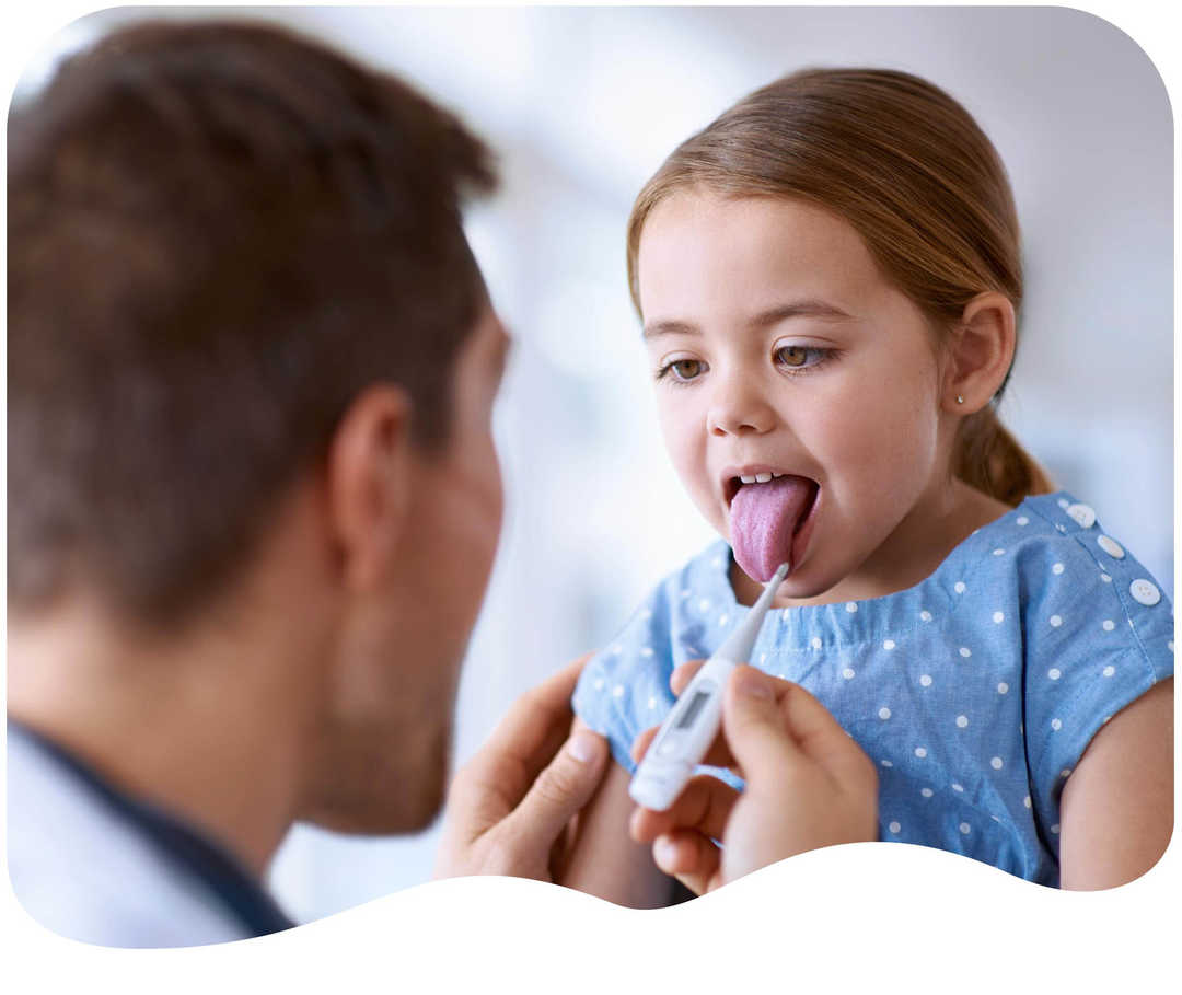 Kleines Mädchen streckt Arzt die Zunge heraus um Fieber gemessen zu bekommen