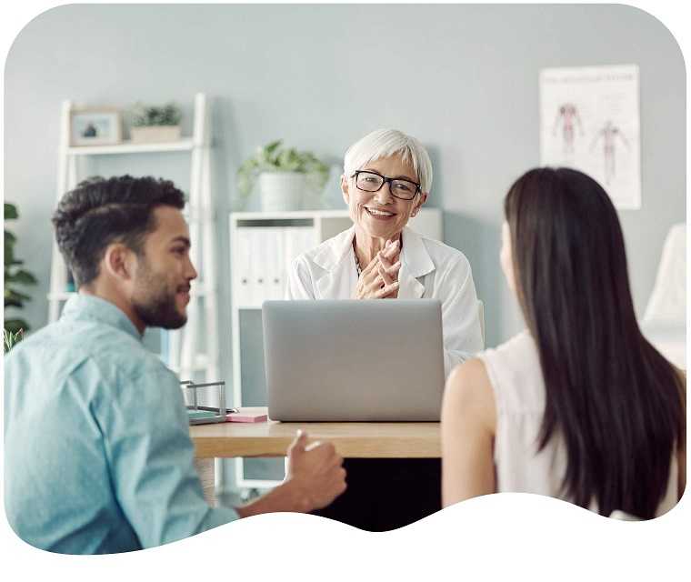 Junges Paar bei einem Beratungsgespräch mit einer Ärztin